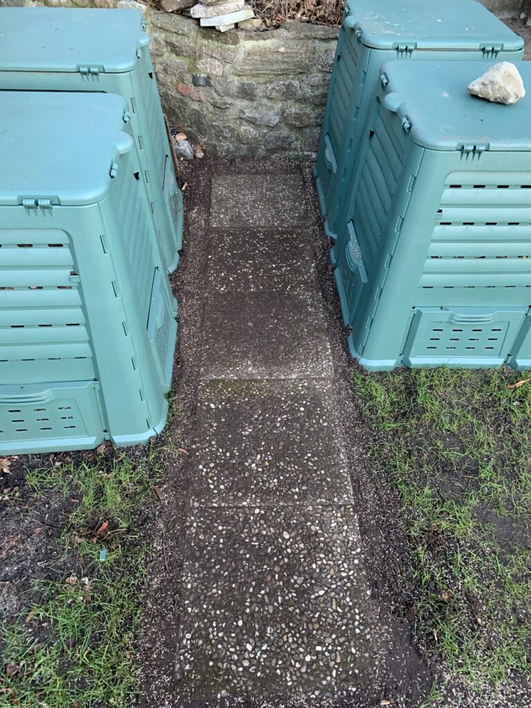 Gehwegplatten, dicht an dicht, in der Kompost-Ecke